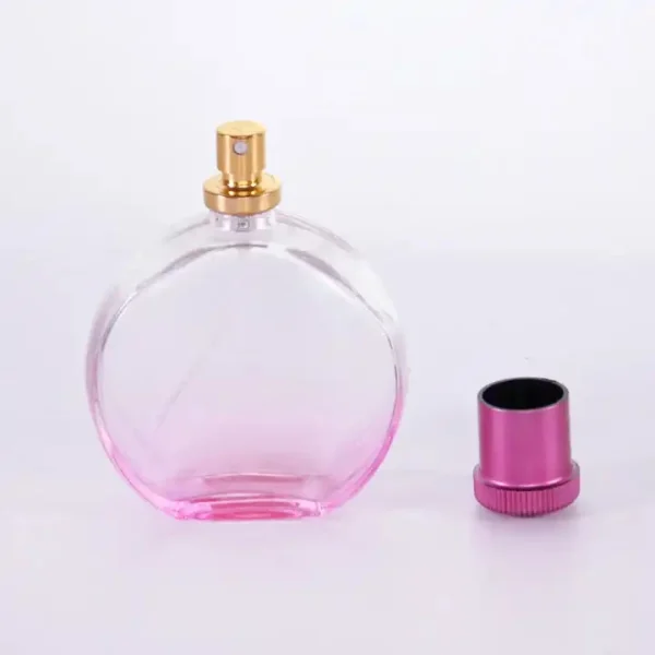Flacone di profumo rotondo rosa da 100 ml con tappo a baionetta in acrilico e spruzzatore in alluminio dorato - immagine 2